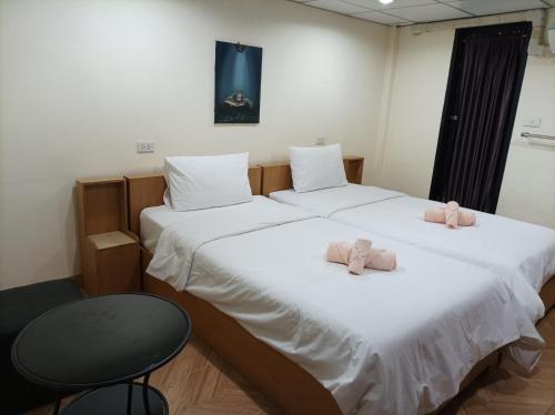 two beds in a room with two pink stuffed animals on them at Double D Rooms & Cafe in Bangkok