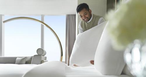 a man standing in a hotel room looking at a bed at Four Seasons Hotel Riyadh in Riyadh
