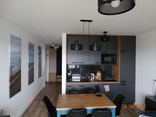 a kitchen and a dining room with a table at Apartament na Piaskowej in Żarnowska