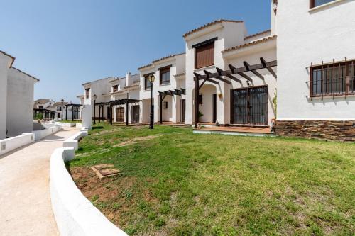 una fila de edificios blancos con un patio en Casa Rural Sierramagna de 2 Dormitorios, en El Ronquillo