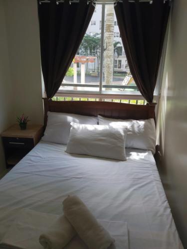 a bed in a room with a large window at Affordable Tagaytay Monteluce 1 BR WITH POOL in Lalaan Primero