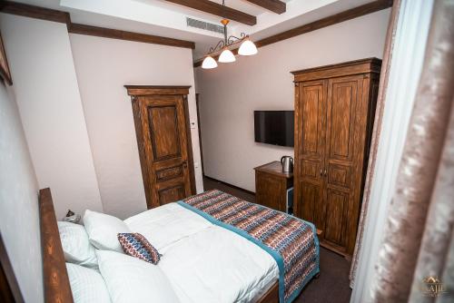 a bedroom with a bed and a cabinet and a tv at Maajid Boutique Hotel in Baku