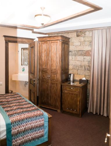a bedroom with a bed and wooden cabinets and a sink at Maajid Boutique Hotel in Baku