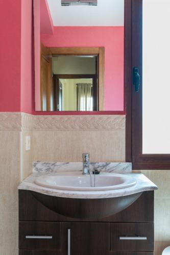 a bathroom with a sink and a mirror at Casa Rural Sierramagna de 2 Dormitorios in El Ronquillo