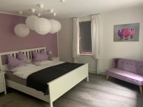 a bedroom with a bed and a pink chair at Ferienwohnung an der Oker in Altenau