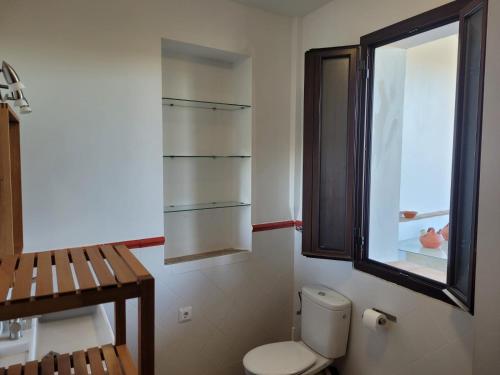 a bathroom with a toilet and a window at Casa Aldea de la Corte 