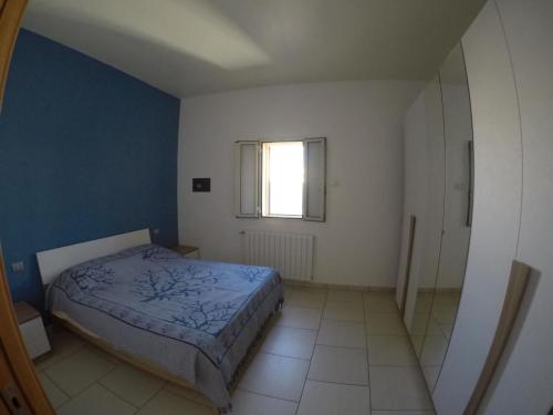 een kleine slaapkamer met een bed en een raam bij La finestra sul porto in Monopoli