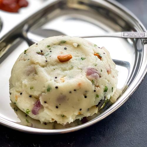 a ball of mashed potatoes on a plate with a spoon at Red Stones Resorts,Karjat in Karjat