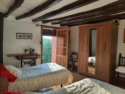 索里亞的住宿－El balcón de Reznos, Soria，一间卧室设有两张床、一张桌子和一个窗口。