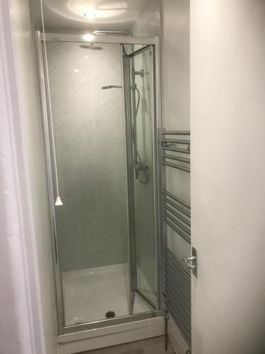 um chuveiro com uma porta de vidro na casa de banho em Myrtle Villa Rooms em Weymouth