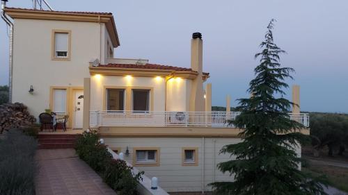 Cette grande maison blanche dispose d'une véranda et d'un arbre de Noël. dans l'établissement Magnificent View Villa, à Alexandroúpolis