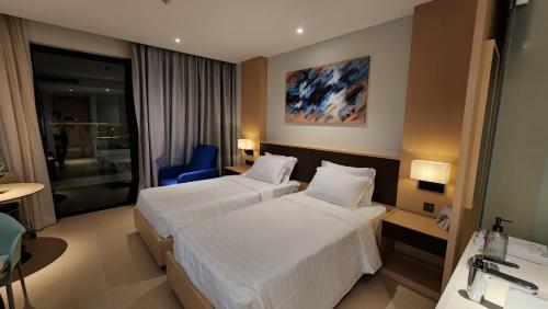 a hotel room with two beds and a blue chair at Apartment Cam Ranh in Thôn Hòa Ða