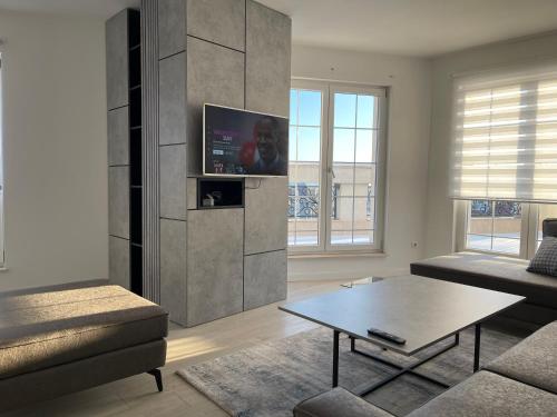 a living room with a tv on a wall at Downtown Apartments in Pristina