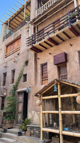 an old stone building with windows and a balcony at نزل حارة المسفاة Harit AL Misfah Inn in Misfāh