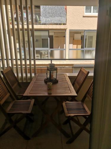 une table en bois et deux chaises sur un balcon dans l'établissement Magnifique T2 les pieds dans le sable, au Grau-du-Roi