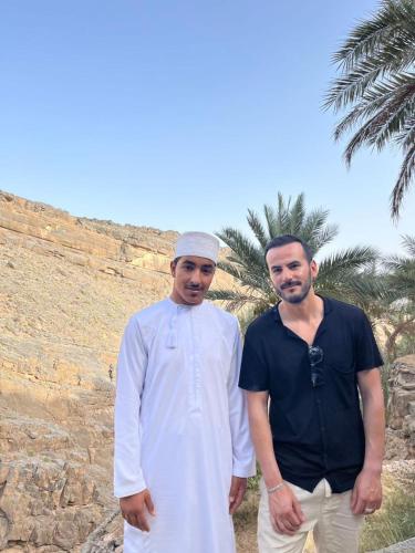 two men are standing next to each other at نزل حارة المسفاة Harit AL Misfah Inn in Misfāh