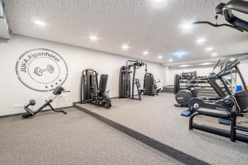 a gym with treadmills and machines in a room at JUFA Alpenhotel Saalbach-Jokercard im Sommer inklusive in Saalbach Hinterglemm