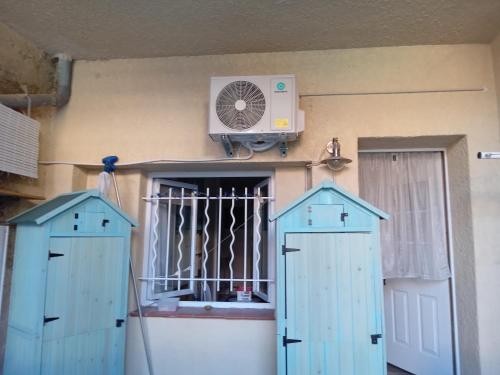 Cette chambre dispose de deux portes bleues et d'un ventilateur. dans l'établissement Joli Studio avec jardin, à Espira-de-lʼAgly