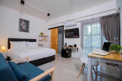 1 dormitorio con 1 cama y escritorio con ordenador en Laewan Guesthouse, en Baan Tai