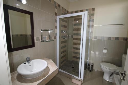 a bathroom with a sink and a shower and a toilet at Saints View Resort Unit 23 in Uvongo Beach