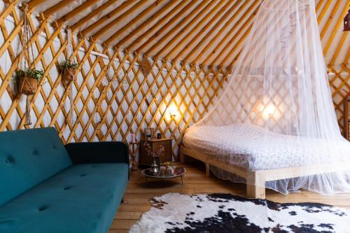 a room with a bed and a couch in a yurt at YURs in Baexem