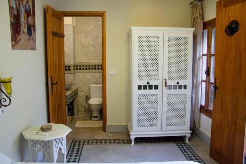 a bathroom with a toilet and a white door at Dar El Halfaouine in Tunis