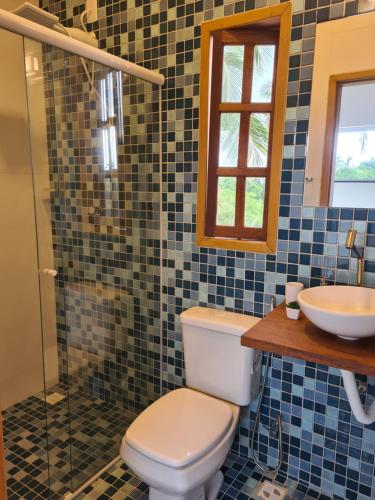 a bathroom with a toilet and a sink at Casa Terracota 2 - Beleza, conforto e sofisticação à 50m do rio in Caravellas
