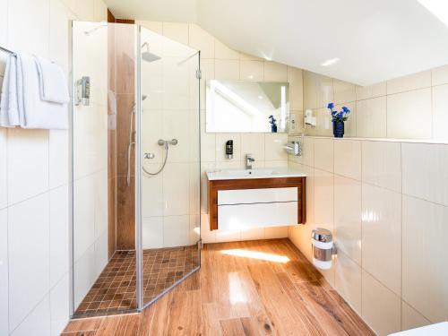 ein Bad mit einer Dusche und einem Waschbecken in der Unterkunft Kristallhotel Fettehenne in Leverkusen