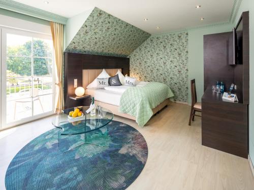 a bedroom with a bed and a glass table at Kristallhotel Fettehenne in Leverkusen