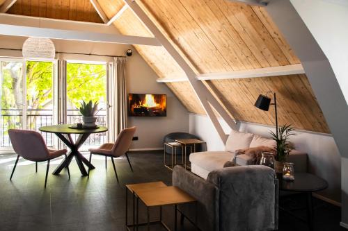 uma sala de estar com um sofá e uma mesa em Appartement de Hoge Stoep em Hollum