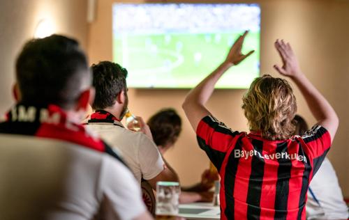 a group of people sitting in a classroom with their hands up at Kristallhotel Fettehenne in Leverkusen