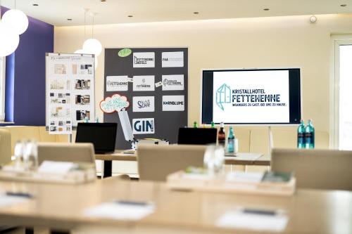 a meeting room with tables and a projection screen at Kristallhotel Fettehenne in Leverkusen