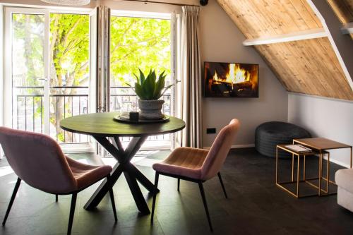 a living room with a table and chairs and a fireplace at Appartement de Hoge Stoep in Hollum