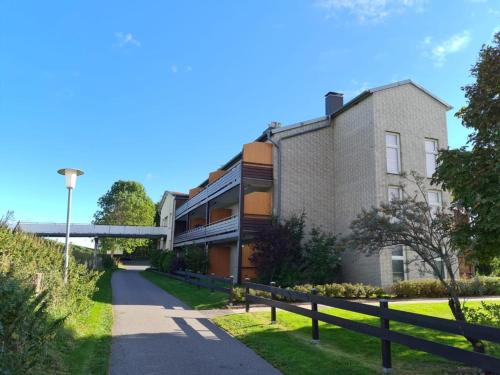 a building with a fence next to a road at Stylische Wohnung mit Weitblick und großem Balkon in Karolinenkoog