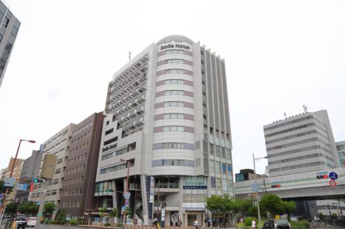a tall white building on a city street at Smile Hotel Osaka Yotsubashi in Osaka