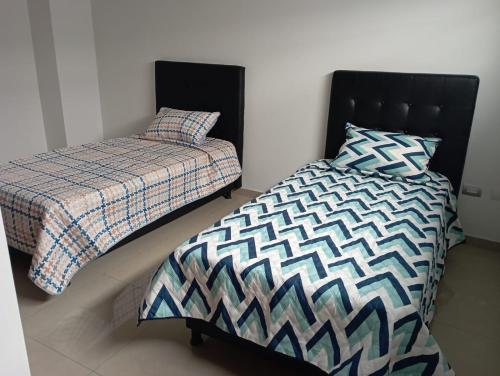 dos camas sentadas una al lado de la otra en un dormitorio en Apartamentos Claudia María, en Barbosa