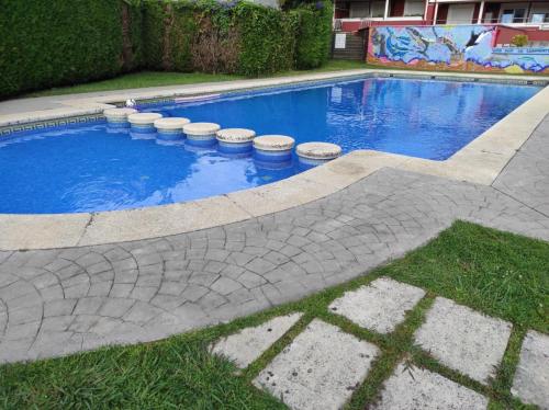 uma piscina com barris à volta num quintal em Apartamento Carril - Camiño do Carro em Vilagarcía de Arousa