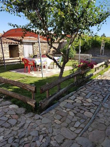 una cerca con una mesa y un árbol en un patio en 'Mi casita' Típica, Tranquila y Acogedora, en Montejo