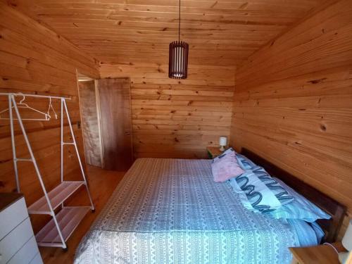 a bedroom with a bed in a wooden cabin at Hermosa cabaña con vista al lago Vichuquén in Vichuquén