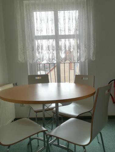 mesa y sillas en una habitación con ventana en Hotel zum Torwächter en Pritzwalk