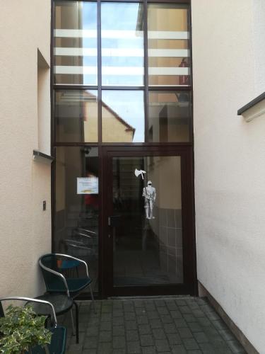 a glass door with a man standing inside of it at Hotel zum Torwächter in Pritzwalk