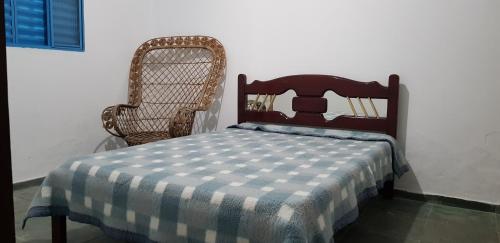 una cama con una manta a cuadros sentada junto a una silla en Bela Chácara en Suzano