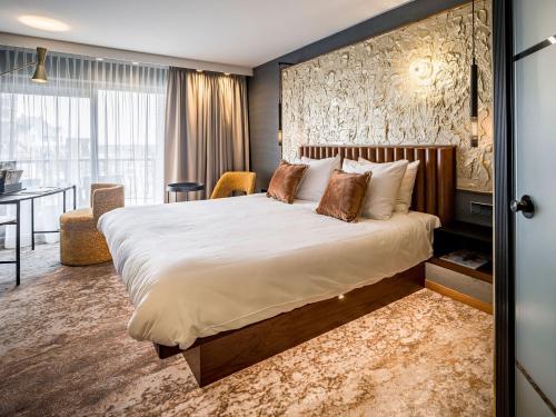 une chambre d'hôtel avec un grand lit et un bureau dans l'établissement Alexander Hotel, à Noordwijk aan Zee