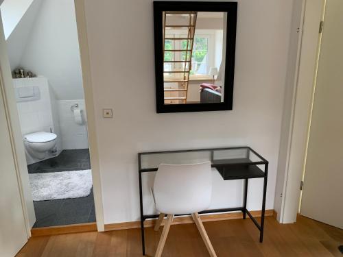 a bathroom with a white chair and a mirror at Ferienwohnung Moseltraum in Cochem