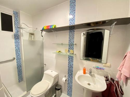 La petite salle de bains est pourvue de toilettes et d'un lavabo. dans l'établissement Franches Apt, Amplio apartamento Familiar amoblado, San Lorenzo Salinas, à Salinas