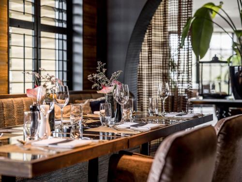 a table in a restaurant with glasses on it at Alexander Hotel in Noordwijk aan Zee
