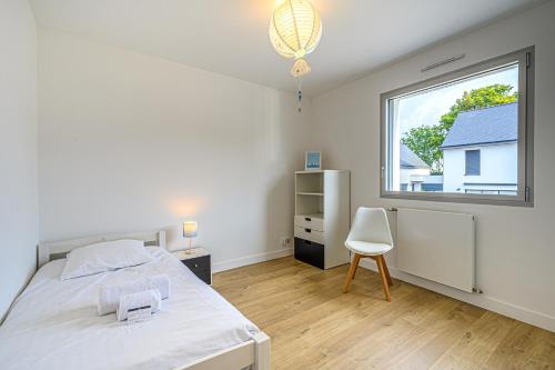 een slaapkamer met een bed en een raam bij RETOUR DE PLAGE - Maison familiale à 400 m de la plage! in Arradon