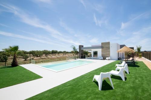 a villa with a swimming pool and green grass at Monte Calmaria by Estilo Lusitano, with private pool and Jacuzzi in Grândola