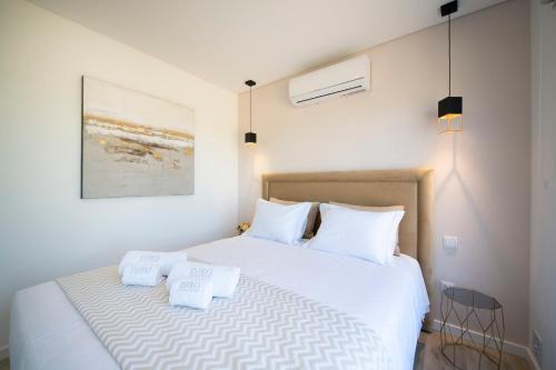 Monte Lusitano Calmaria في غراندولا: غرفة نوم بسرير ابيض مع وسادتين بيض