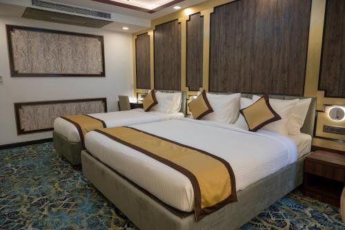 a hotel room with two beds in it at Golden Retreat in Baharampur